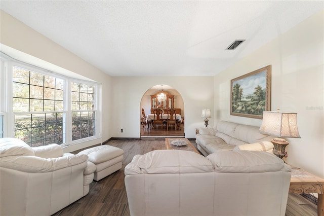 living room featuring a textured ceiling and dark hardwood / wood-style floors