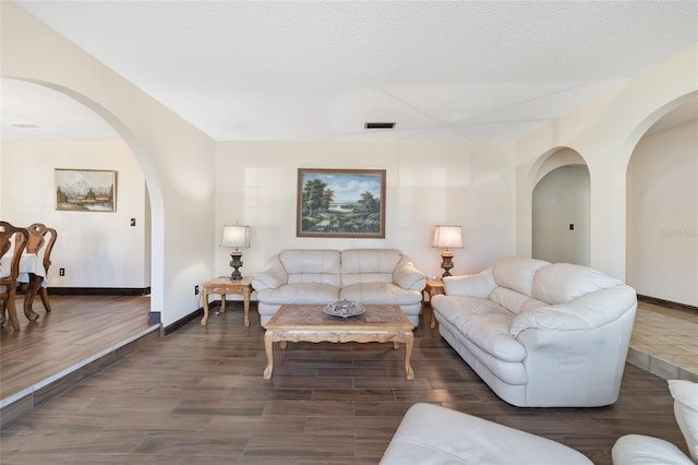 living room with dark hardwood / wood-style flooring and a textured ceiling