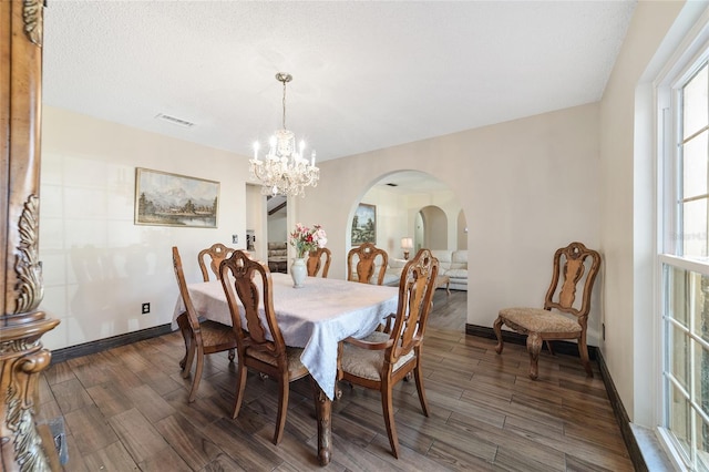 dining area featuring a chandelier and a textured ceiling