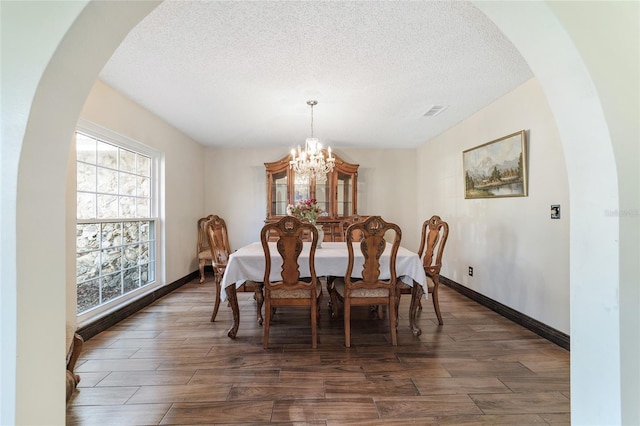 dining area featuring a chandelier and a textured ceiling