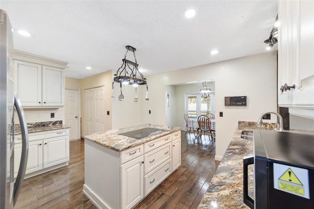 kitchen featuring black electric cooktop, white cabinets, and a kitchen island