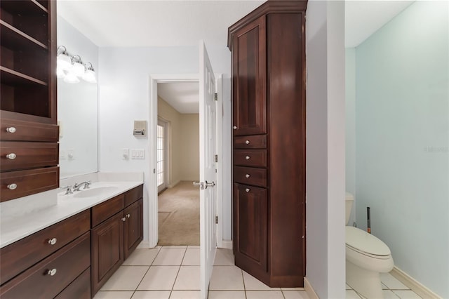 bathroom with toilet, vanity, and tile patterned floors