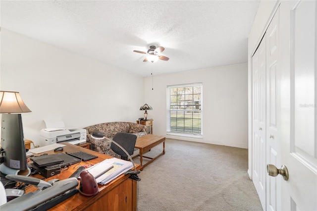 office featuring ceiling fan, light colored carpet, and a textured ceiling