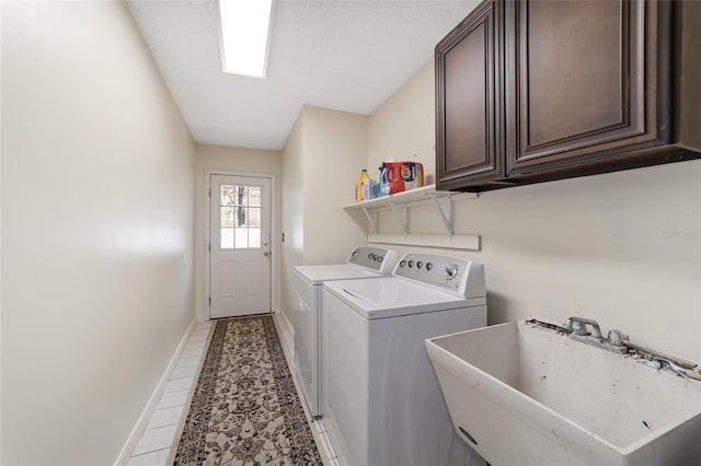 laundry area with cabinets, independent washer and dryer, light tile patterned floors, and sink