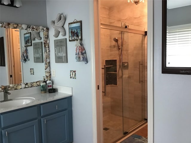 bathroom with a shower with door and vanity