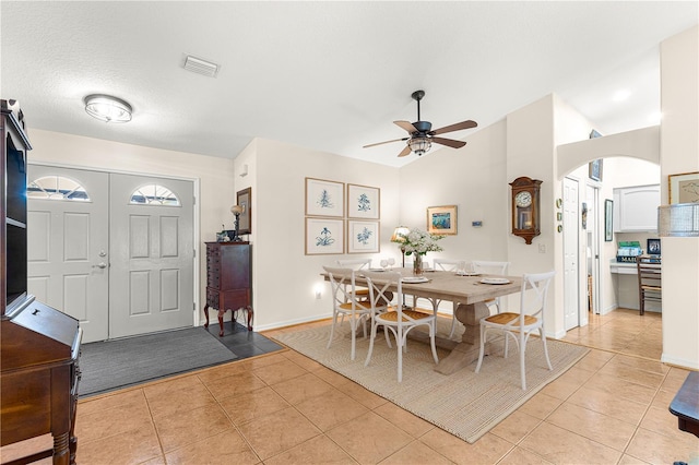 dining room featuring light tile patterned floors, visible vents, a ceiling fan, and vaulted ceiling