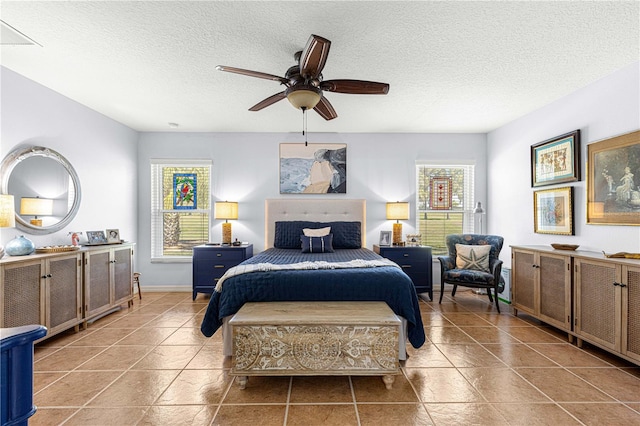 bedroom with baseboards, tile patterned flooring, a textured ceiling, and ceiling fan