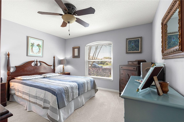 bedroom with baseboards, light carpet, a textured ceiling, and ceiling fan