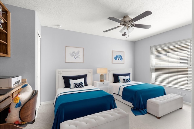 carpeted bedroom featuring baseboards, a textured ceiling, and ceiling fan