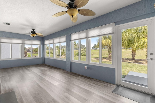 unfurnished sunroom with visible vents and ceiling fan