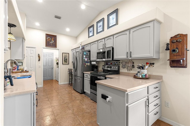 kitchen featuring visible vents, a sink, appliances with stainless steel finishes, light countertops, and lofted ceiling