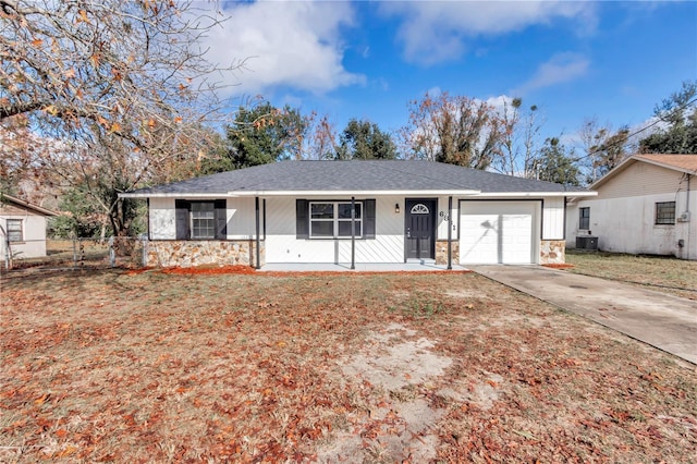 ranch-style home featuring a garage, covered porch, a front yard, and central AC