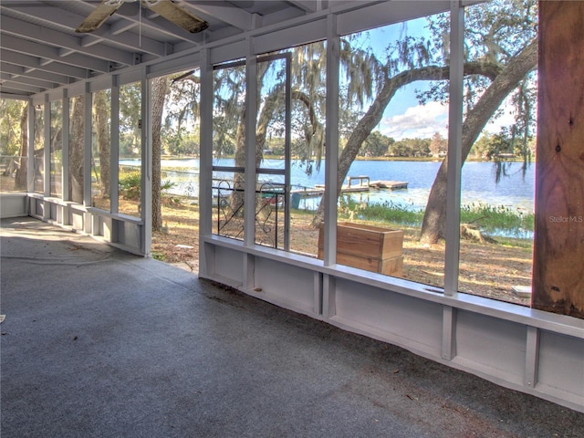 unfurnished sunroom featuring ceiling fan, plenty of natural light, and a water view