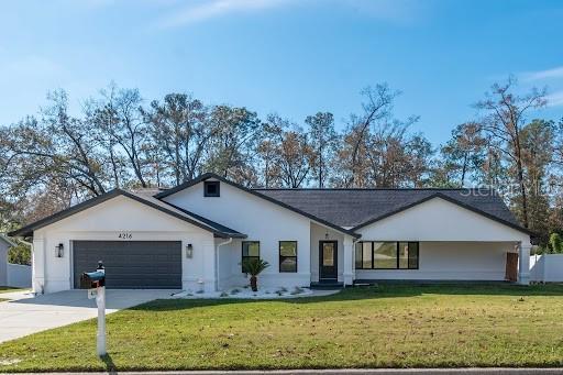 ranch-style house with a garage and a front lawn