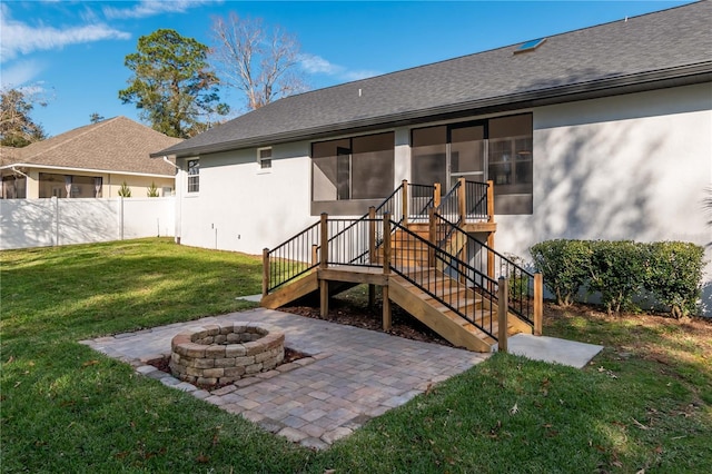 rear view of property with a lawn and an outdoor fire pit