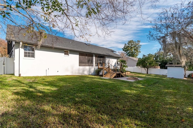 rear view of property with a lawn and a fire pit