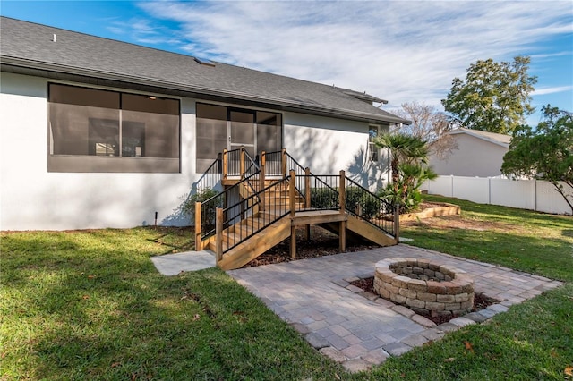 rear view of house with a lawn, a patio area, and an outdoor fire pit