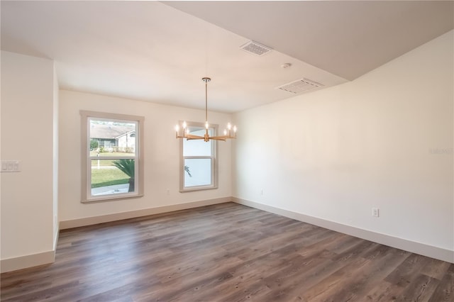 unfurnished dining area featuring an inviting chandelier and dark wood-type flooring