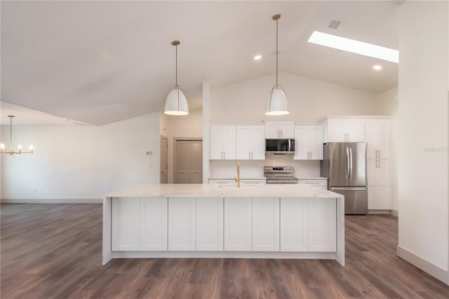 kitchen featuring a skylight, stainless steel appliances, white cabinets, dark hardwood / wood-style floors, and hanging light fixtures