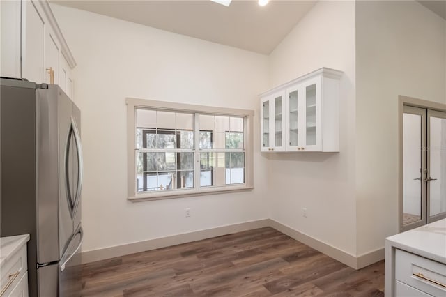 kitchen with white cabinets, stainless steel fridge, dark hardwood / wood-style floors, and high vaulted ceiling