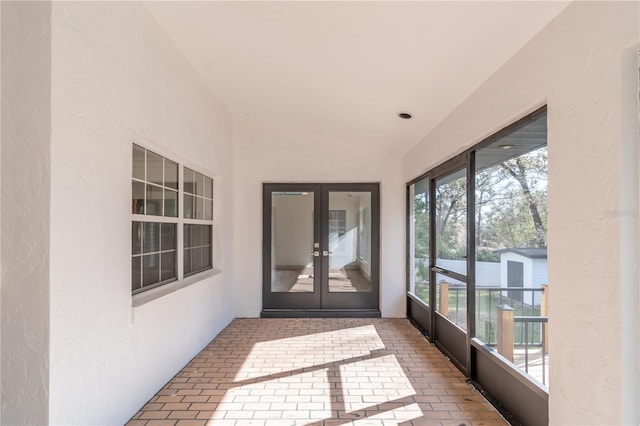 unfurnished sunroom featuring french doors and vaulted ceiling