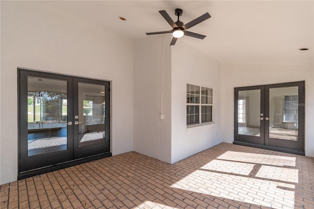 view of exterior entry with ceiling fan, a patio area, and french doors