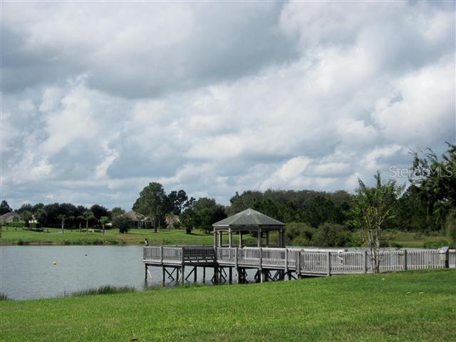 view of dock featuring a gazebo, a yard, and a water view