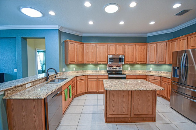 kitchen with kitchen peninsula, appliances with stainless steel finishes, ornamental molding, and sink