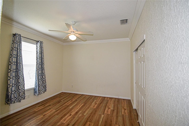 unfurnished room featuring ceiling fan, hardwood / wood-style floors, plenty of natural light, and ornamental molding