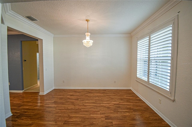 empty room with crown molding, dark wood-type flooring, a textured ceiling, and an inviting chandelier