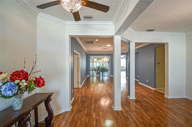 interior space featuring a textured ceiling, dark hardwood / wood-style flooring, crown molding, and a chandelier