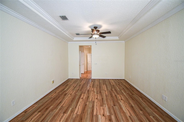 spare room featuring hardwood / wood-style flooring, ceiling fan, a raised ceiling, and crown molding