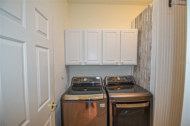 washroom featuring cabinets and washing machine and clothes dryer