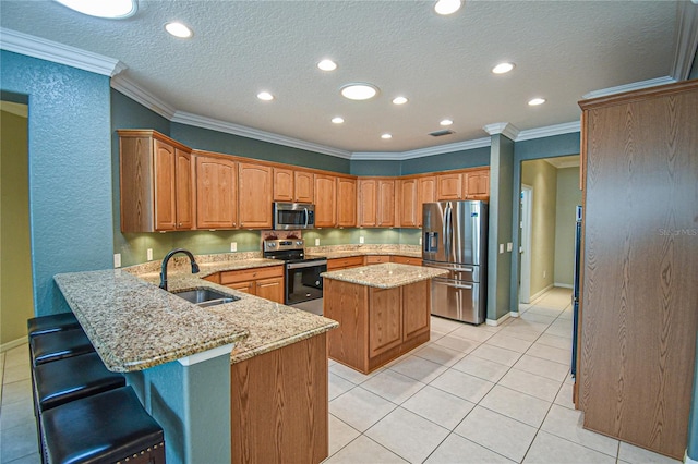 kitchen with kitchen peninsula, a kitchen breakfast bar, stainless steel appliances, sink, and a center island