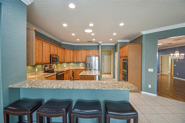 kitchen with kitchen peninsula, light tile patterned floors, stainless steel appliances, and ornamental molding