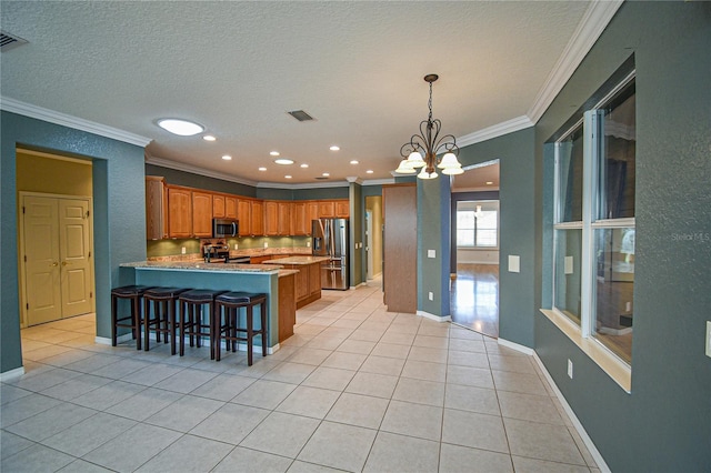 kitchen featuring kitchen peninsula, appliances with stainless steel finishes, a kitchen breakfast bar, ornamental molding, and light tile patterned floors