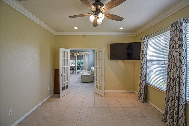 tiled spare room featuring ceiling fan, ornamental molding, and french doors