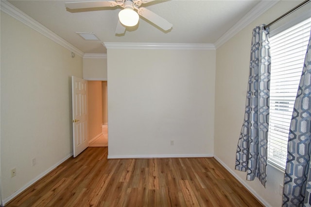 empty room with plenty of natural light, wood-type flooring, and crown molding