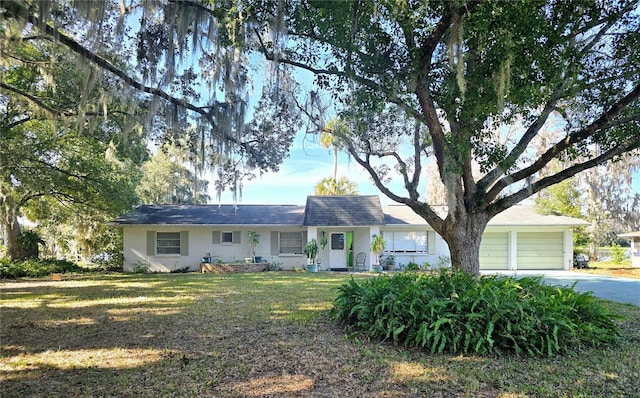 ranch-style home with a garage and a front lawn