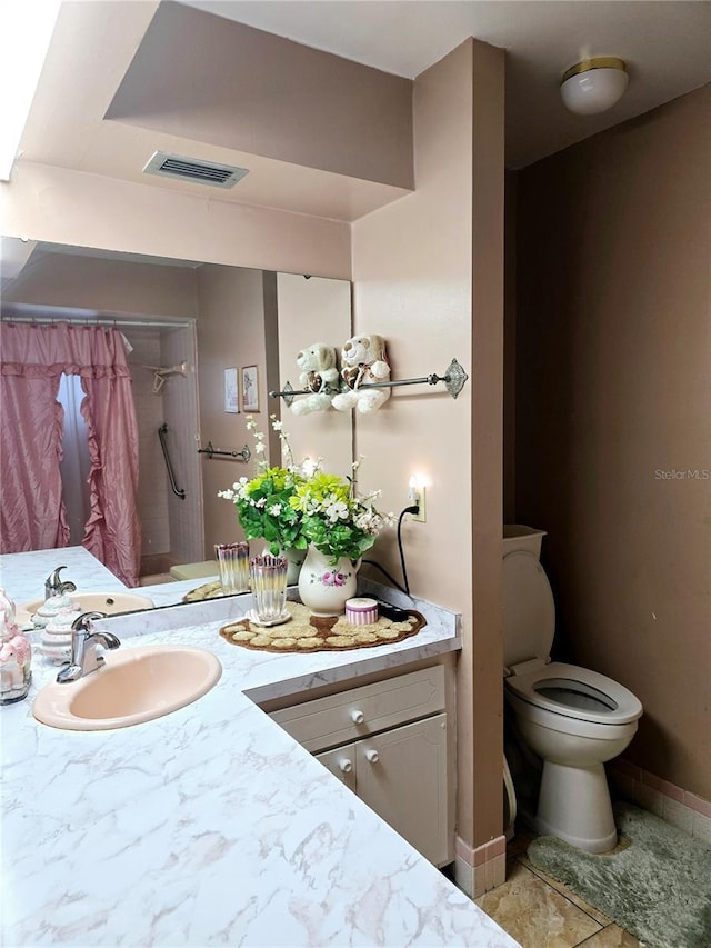 bathroom featuring tile patterned flooring, vanity, and toilet