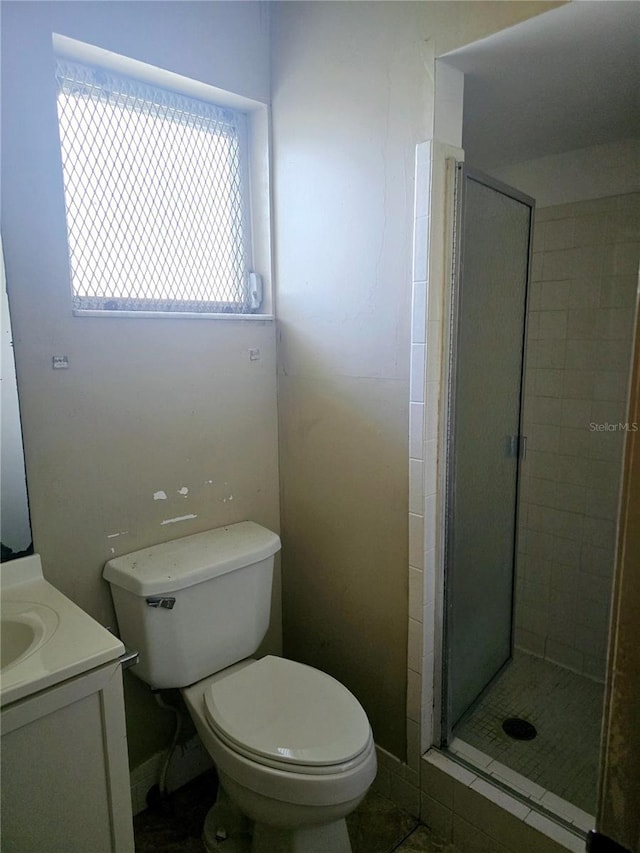 bathroom with toilet, vanity, and walk in shower