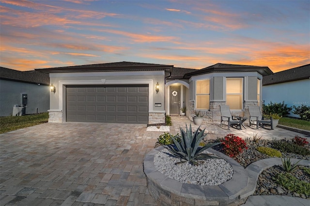 view of front of property featuring a patio area and a garage