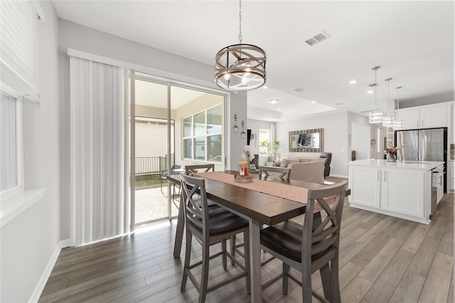 dining room featuring a notable chandelier, dark hardwood / wood-style flooring, and sink