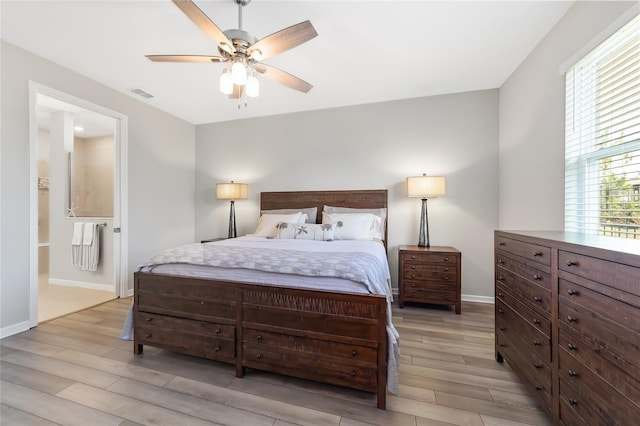 bedroom with ceiling fan, light wood-type flooring, and ensuite bath