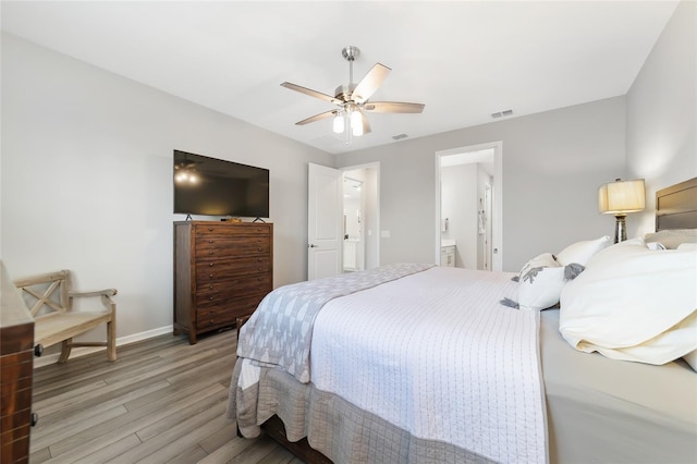 bedroom with light wood-type flooring, ensuite bath, and ceiling fan