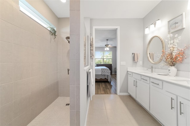 bathroom featuring tile patterned floors, ceiling fan, vanity, and a tile shower