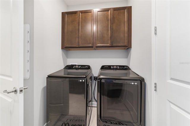 laundry room with washer and clothes dryer and cabinets