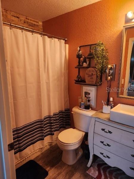 113 Guava Ter, Ocklawaha, FL 32179 - bathroom with toilet, wood finished floors, vanity, a textured ceiling, and a textured wall