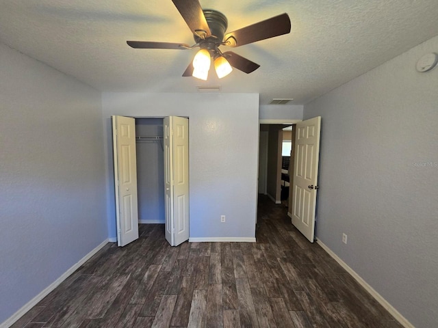 113 Guava Ter, Ocklawaha, FL 32179 - unfurnished bedroom with dark wood-style flooring, a textured ceiling, baseboards, and a closet
