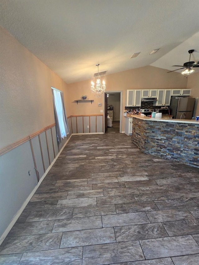 113 Guava Ter, Ocklawaha, FL 32179 - kitchen with lofted ceiling, freestanding refrigerator, a chandelier, a ceiling fan, and white cabinetry